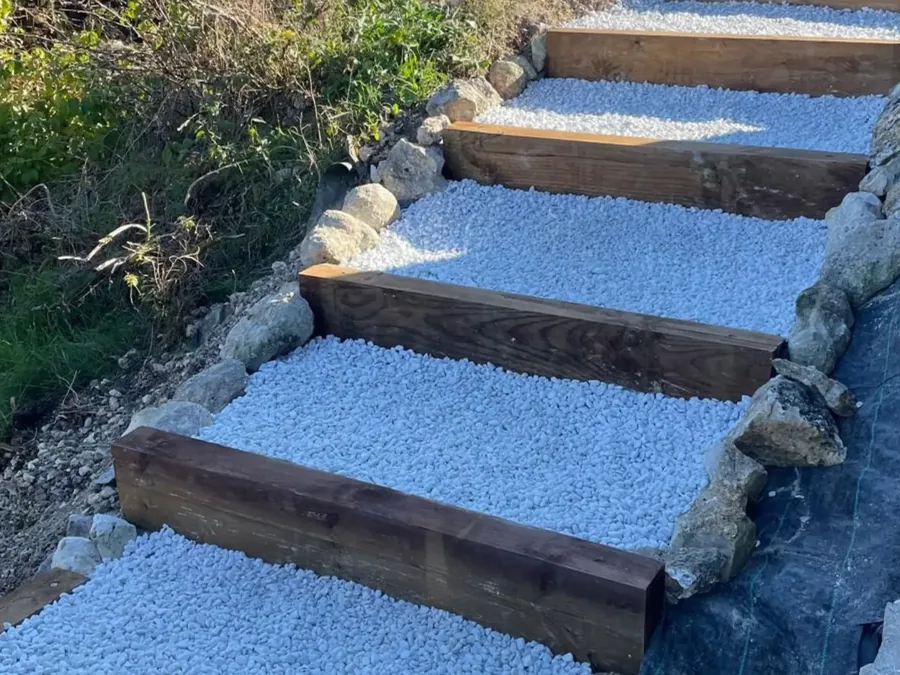 Escalier extérieur en traverses bois et gravier, aménagement de terrain en pente