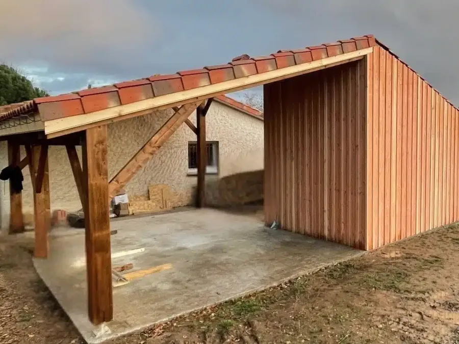 Carport en bois avec charpente traditionnelle et bardage, adossé à une maison, à Bergerac