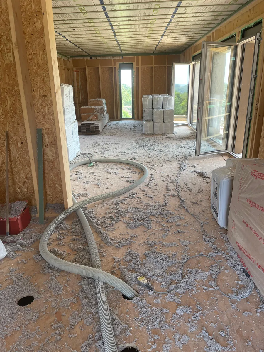Ballots de ouate de cellulose stockés dans une maison à ossature bois, frein-vapeur posé au plafond
