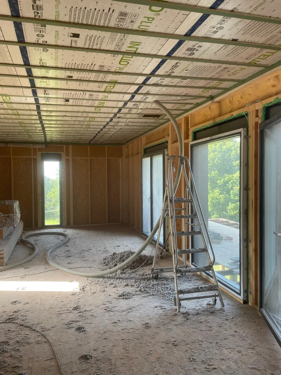 Isolation insufflée posée entre les solives, grandes menuiseries posées, sur un chantier ACMT
