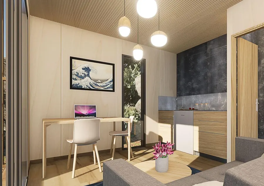 Pièce de vie en bois clair avec table, kitchenette et suspensions