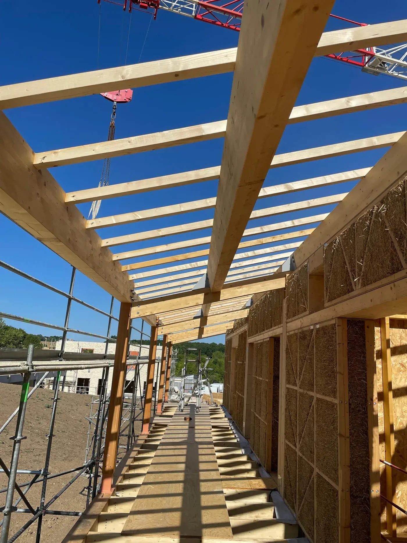 Construire en bois et paille : charpente et murs en bottes de paille, chantier du Village des Pruniers
