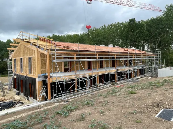 Bâtiment bois-paille sous échafaudage, couverture en tuiles
