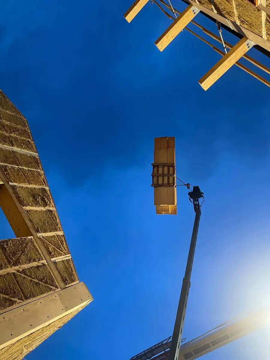 Panneau de paille levé dans le ciel bleu, chantier bois-paille