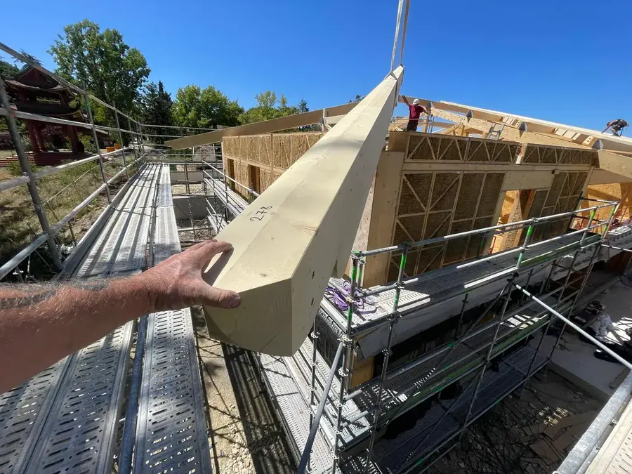 Pose d'une poutre en lamellé-collé sur le chantier bois-paille
