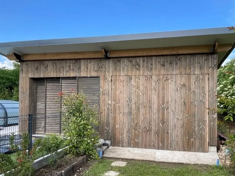 Poolhouse en bois rénové avec bardage vertical et volets à lames, au bord d'une piscine, à Bergerac